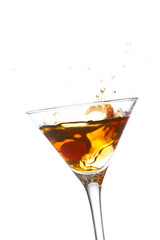 Two red cherrys splashing into a cocktail glass
