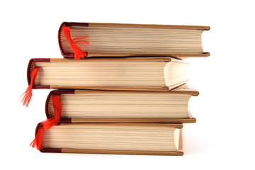 Four stacked books with red bookmarks on white