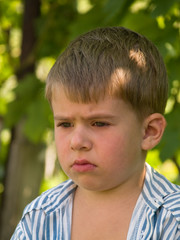 little sadden boy portrait over bight summer background.