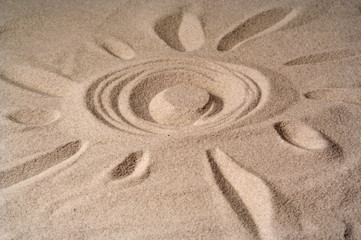 Fototapeta na wymiar draw of a sun on sand