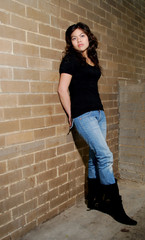 Asian female posing against a brick wall