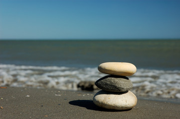 Fototapeta na wymiar Three balanced stones on the beach