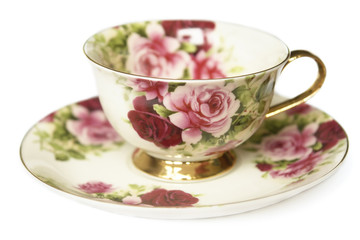 teacup on saucer decorated with gold and roses