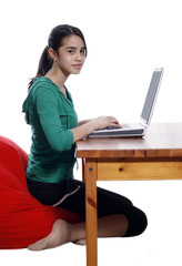 Young pretty women on red bean bag relaxing and using laptop
