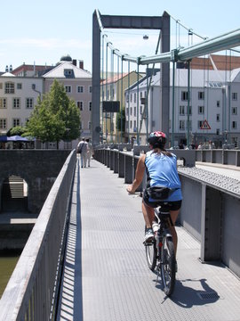radfahrerin f&auml;hrt &uuml;ber br&uuml;cke in passau