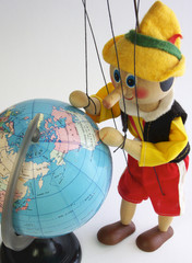 Wooden puppet looks at Globe