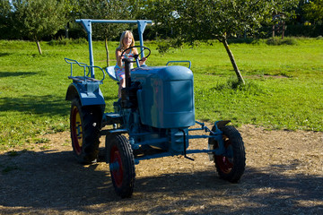 Obraz premium Farmer's daughter on a tractor