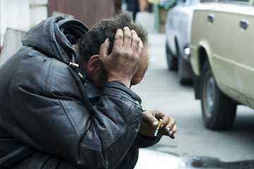 Sad homeless man on city street