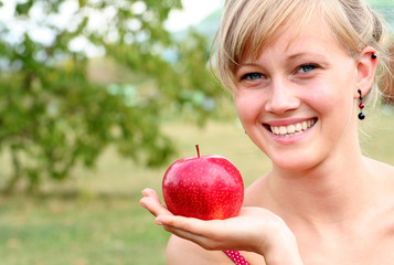 Young woman holding apple, smiling