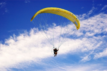 Paraglider against a  vibrant blue sky