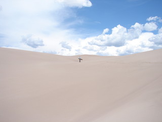 Fototapeta na wymiar Snowboarder hiking up the Great Sand Dunes