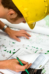 construction worker checking documents and maps