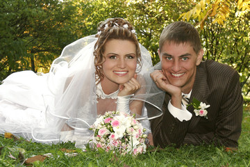 bride and groom laying on the grass