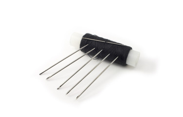 Five needles and spool of black thread