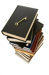 Huge stack of books with a skeleton key on top