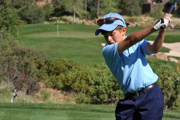 Young male about to tee off with flag visible, focus on golfer