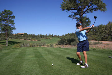 Young male golfer about to tee off on beautiful golf course