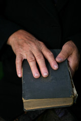 Senior's hands on old book