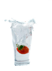 splashing strawberry into a water glass