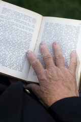 Senior's hands on old book