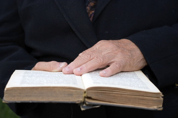 Senior's hands on old Bible