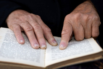 Senior's hands on old Bible