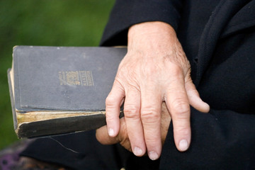 Senior's hands on old book