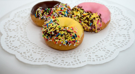 colorful iced donuts on white plate