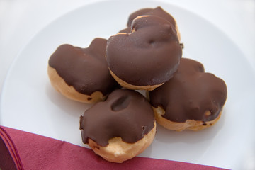 profiteroles on white plate with red napkin
