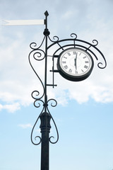 Fototapeta na wymiar street clock with a flag