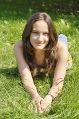 young brunette girl lying on the grass