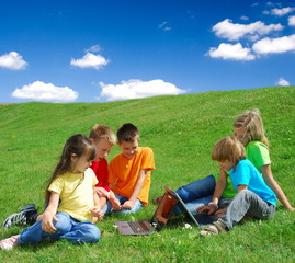Fototapeta premium Kids in a Meadow with Laptops
