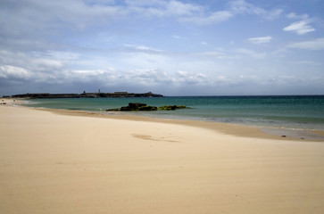 Fototapeta na wymiar Piaszczysta plaża w Hiszpanii. Niebo i chmury.
