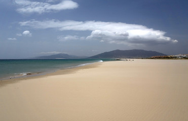 Fototapeta na wymiar Piaszczysta plaża w Hiszpanii. Niebo i chmury.