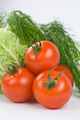 Pile of tomatoes with lettuce and dill on the background