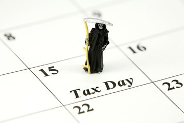 Miniature grim reaper on a calendar on Tax Day, April 15th.