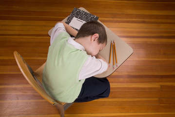 Boy sleeping at school desk