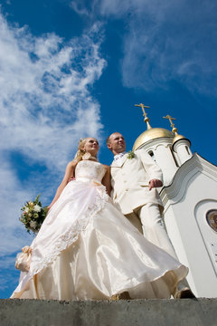 Newlyweds in front of church.