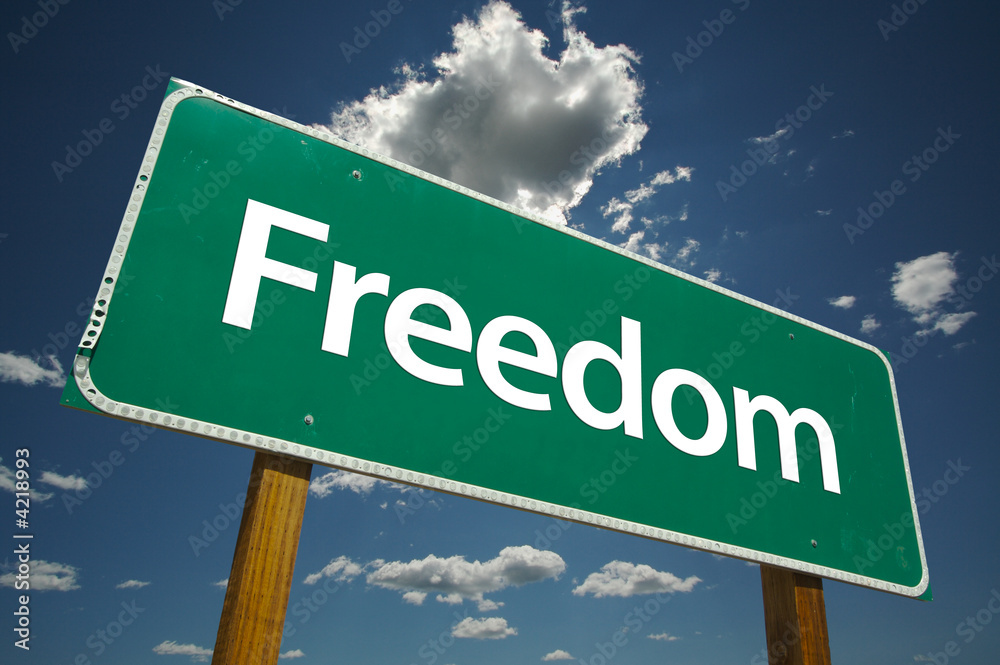 Wall mural Freedom Road Sign with blue sky and clouds.