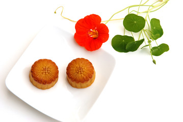 moon cake and nasturtium flower on white background