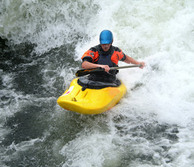 Fototapeta na wymiar Człowiek wiosłowaniu jego Kayak na Whitewater Rapids