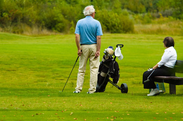 senior couple playing golf