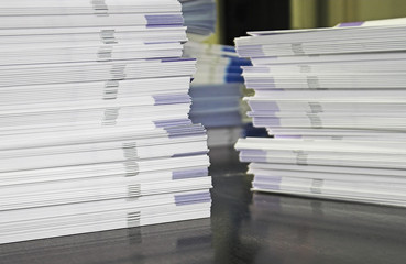 Piles of handout papers lying on a table.