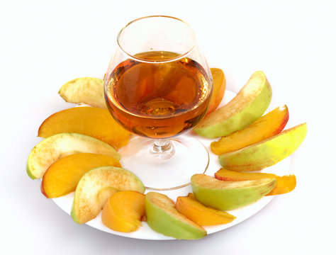 Sliced fruits and glass of brendy