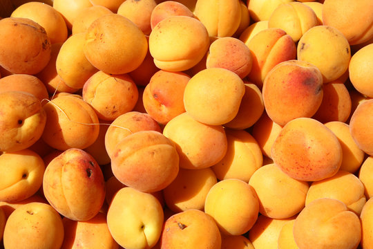 Lots of apricots outside a greengrocer shop.