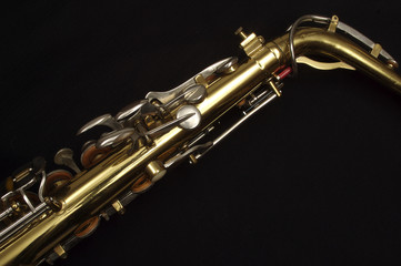 Saxophone against black, neck and top keys, diagonal