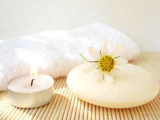 cosmetic soap and candle with flower