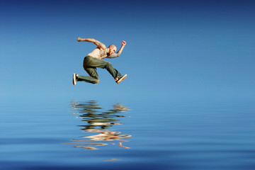 Athletic man jumping on water