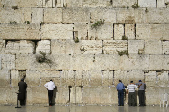 men praying next to the wailing wall, jerusalem,israel