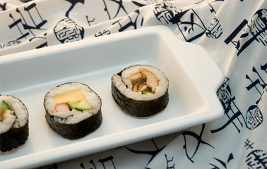 sushi rolls on white plate with kimono background